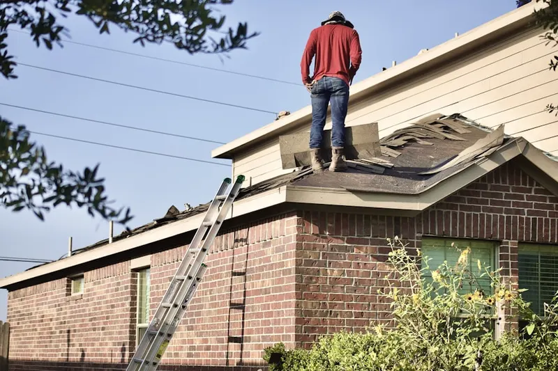Professional roofer working on a residential roof in Dunbarton